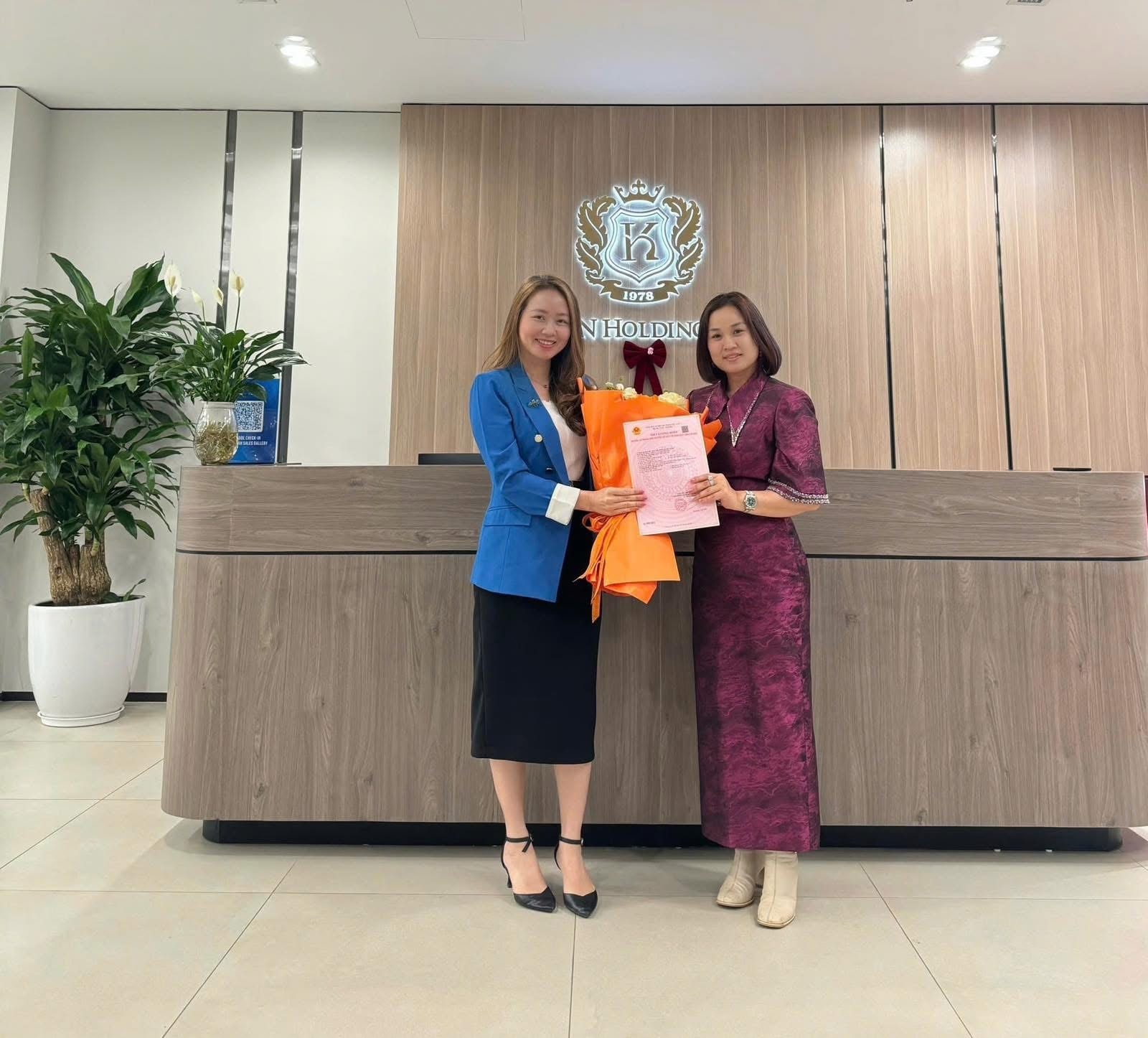 Đại diện KN Holdings trao sổ hồng cho khách hàng nữ tại văn phòng
